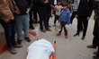 Mourners gather around the bodies of Palestinians at Al Shifa Hospital in Gaza City, on Ap...