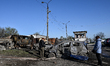 Women look at a car destroyed in a drone strike at a parking lot in Zaporizhzhia, Ukraine,...