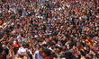 A crowd of revelers holds their phones high to capture the tongue piercing ritual in Bode,...