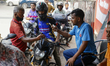 A fuel pump worker checks a QR code as a customer receives an allotment of fuel worth Tk 1...