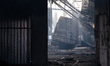 A burnt-out minibus is seen in a building damaged by a Russian military operation in Kyiv,...