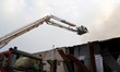 Firefighters use an aerial ladder platform to extinguish a fire at warehouses in Kyiv, Ukr...