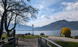 People sit and walk beside Lake Tegernsee in Tegernsee, Upper Bavaria, Bavaria, Germany, o...
