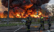 Rescue workers extinguish a fire at a recycling warehouse following a missile and drone st...