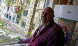 A man stands by a kitchen window knocked out in an apartment block in the Podilskyi distri...