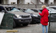 A woman stands by cars in a parking lot in the Podilskyi district, damaged during a Russia...
