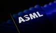 The ASML logo is displayed on a smartphone screen placed on a reflective surface with an a...