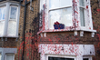 The exterior of a house in Kilburn, London, is seen vandalized with red and black paint on...