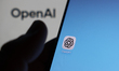 OpenAI website displayed on a laptop screen and ChatGPT icon displayed on a phone screen a...