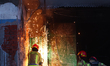 Firefighters work at the scene of a fire at the warehouse storing electric tourist carts i...