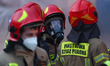 Firefighters work at the scene of a fire at the warehouse storing electric tourist carts i...