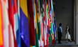 A security guard checks a person's credentials near international flags outside of the Int...