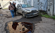 People examine a car near a hostel damaged in Odesa, Ukraine, on April 16, 2026. Overnight...
