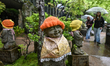 MIYAJIMA, JAPAN - APRIL 15: 
 A smiling stone Jizo statue, adorned with a hand-knitted or...