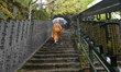 MIYAJIMA, JAPAN - APRIL 15: 
 A Buddhist monk carrying a translucent umbrella ascends the...