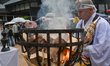 MIYAJIMA, JAPAN - APRIL 15: 
 A Yamabushi monk stands near a sacred fire pit as smoke and...
