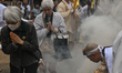 MIYAJIMA, JAPAN - APRIL 15: 
 Devotees and pilgrims walk barefoot through thick smoke and...