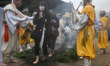 MIYAJIMA, JAPAN - APRIL 15: 
 Devotees and pilgrims walk barefoot through thick smoke and...