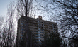 A dilapidated 16-storey apartment block, decorated with the USSR's coat of arms, stands as...