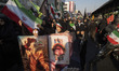 Pro-government supporters carry anti-U.S. posters during a military parade of Iran's self-...