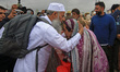 A Kashmiri Hajj pilgrim (left) says goodbye to his relatives as he begins his spiritual jo...