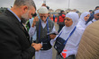 An officer checks the documents of Hajj pilgrims as they begin their journey from Srinagar...