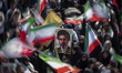 Iranian demonstrators wave national flags and hold a portrait of Iran's Supreme Leader Aya...