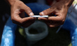 A Palestinian man makes cigarettes from dried molokhia leaves at the tobacco market on Oma...
