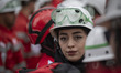 A female member of the Iranian Red Crescent Society's search-and-rescue team looks on befo...