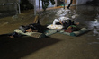 Residents sleep on a bridge after floodwaters inundate their homes in Sawangan, West Java,...