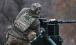 A soldier from the 13th Khartiia Operational Brigade of Ukraine's National Guard adjusts a...