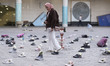 A woman walks through an installation symbolizing the Shajareh Tayyebeh School in Minab, w...