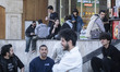 Iranian youths gather on a sidewalk outside a shopping mall in western Tehran, Iran, on Ap...