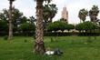 A person lays under a palm tree at the Parc Lalla Hasna in Marrakesh, Morocco on April 23,...