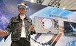 A viewer explores China's space station through virtual reality technology at the 32nd Chi...