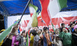 Iranian children salute beneath national flags while participating in a rally in northwest...