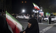Pro-government supporters wave national flags during a rally in northwestern Tehran, Iran,...