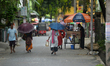 People are seen during rain in Siliguri, India, on April 26, 2026. 