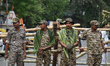 CRPF personnel stand beside the road during a road show of Narendra Modi ahead of the seco...