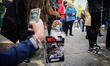 A small dog leans on a sign during the Great March for Animals, Sunday, April 26, 2026, ca...