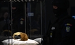 A ceremonial gold helmet and two gold bracelets are displayed during a media presentation...