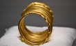 A ceremonial gold helmet and two gold bracelets are displayed during a media presentation...