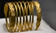 A ceremonial gold helmet and two gold bracelets are displayed during a media presentation...