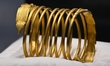 A ceremonial gold helmet and two gold bracelets are displayed during a media presentation...