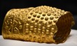 A ceremonial gold helmet and two gold bracelets are displayed during a media presentation...