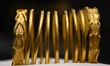 A ceremonial gold helmet and two gold bracelets are displayed during a media presentation...