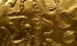 A ceremonial gold helmet and two gold bracelets are displayed during a media presentation...