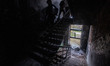 A resident with his belongings descends the stairs of a flat building damaged after a Russ...