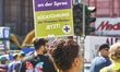 A protester's sign reads ''TVoD fur ALLE an der Spree, RUCKFUHRUNG der Vivantes-Tochter JE...