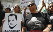 A demonstrator holds a placard with a portrait of detained Tunisian journalist Mourad Zegh...